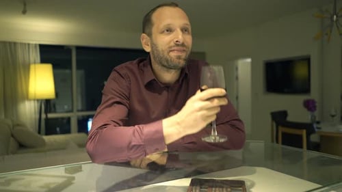 Man Relaxing and Drinking Wine at Home at Night