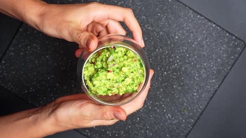 Guacamole with tortilla chip in bowl. Close view of guacamole served with tortilla