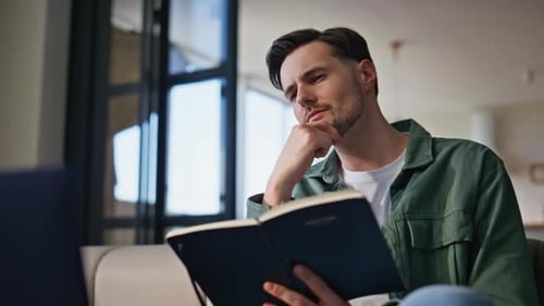 Man Thinking and Writing in Journal at Home