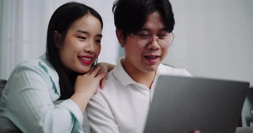 Affectionate Couple Using Laptop Together on Sofa