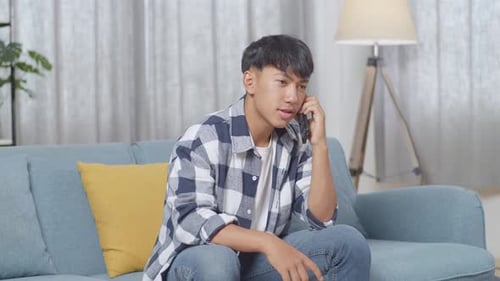 Young Man Chatting on Mobile Phone on Couch