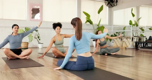 Women Practice Yoga Poses on Mats in Studio