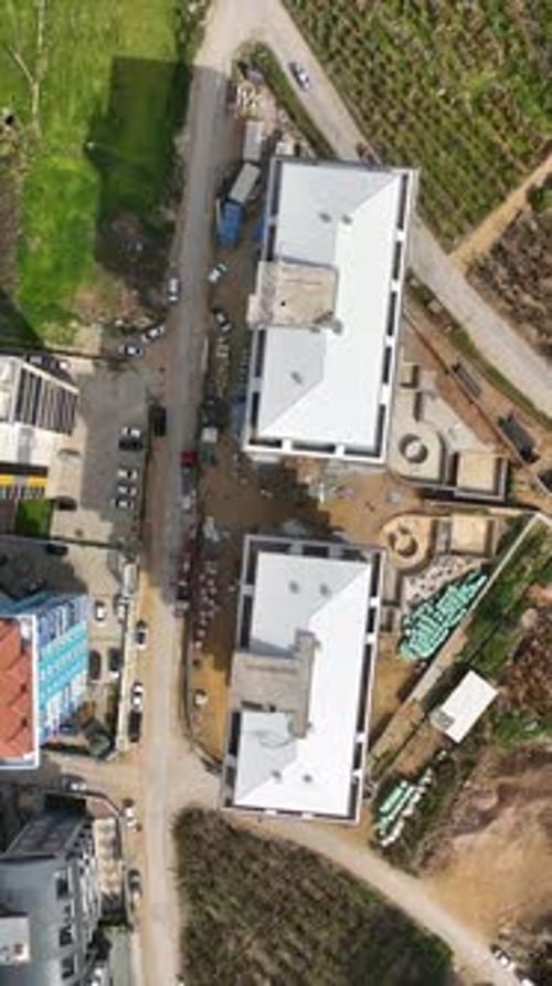 Vertical Video Construction Unveiled Aerial View of MultiStory Building Site in the Making