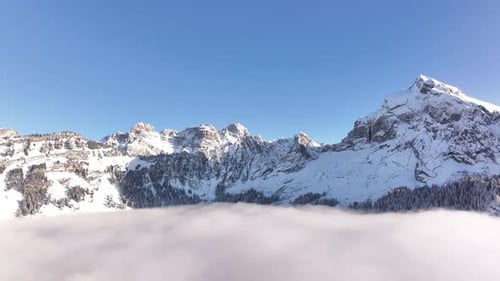 Fronalpstock snowy peaks: alpine winter clouds in Glarus, Switzerland