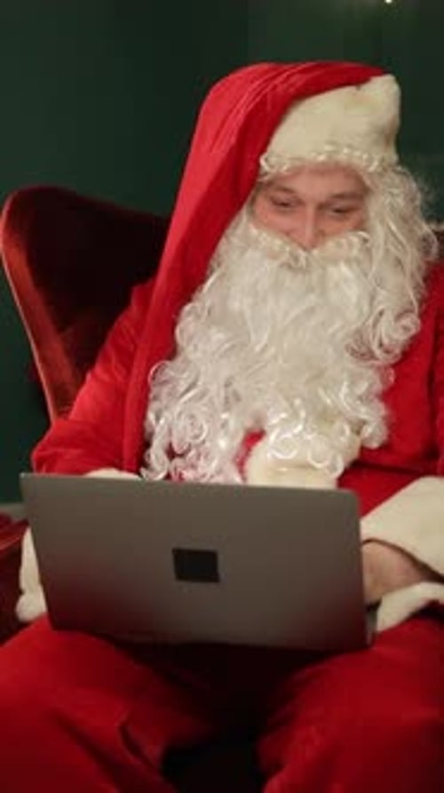 Santa Claus Typing on a Laptop in a Cozy Festive Christmas Room Vertical Video