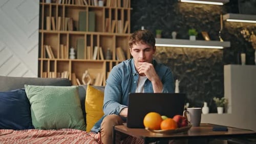 Young Adult Works on Laptop at Home