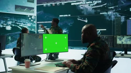 Soldier Analyzing Real Time Data Next to Green Screen in High Tech Office