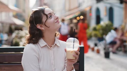 Woman Enjoying Drinking Morning Cold Coffee Drink with Ice Relaxing Taking a Break in City Street