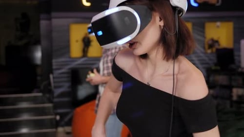 Dos adolescentes jugando a videojuegos con un casco de realidad virtual con gafas