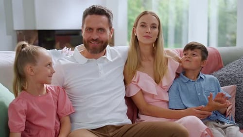 Smiling Family Relaxing Together on Couch at Home