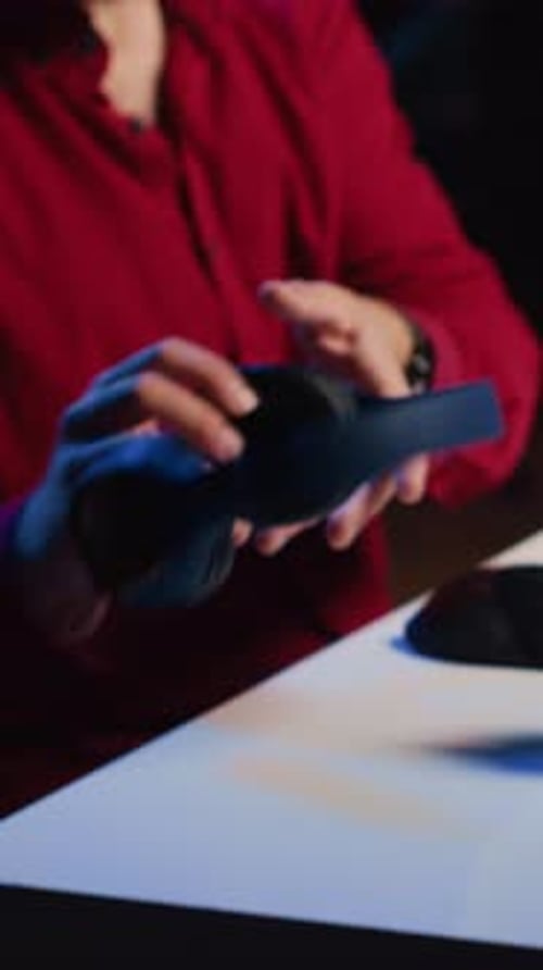 Man Puts on Headphones While Using Computer