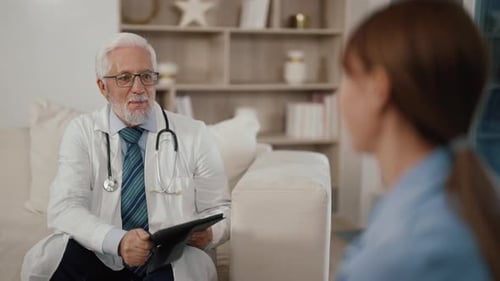 Senior Man Therapist Consults Woman Medical Appointment to Young Patient in Modern Clinic Female Has