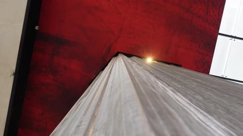 Slow orbiting shot around the base of a stone column with a red roof