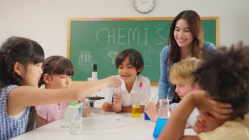 Adorable student learn with teacher in classroom at elementary school.