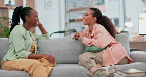 Two Friends Talking on a Couch Indoors