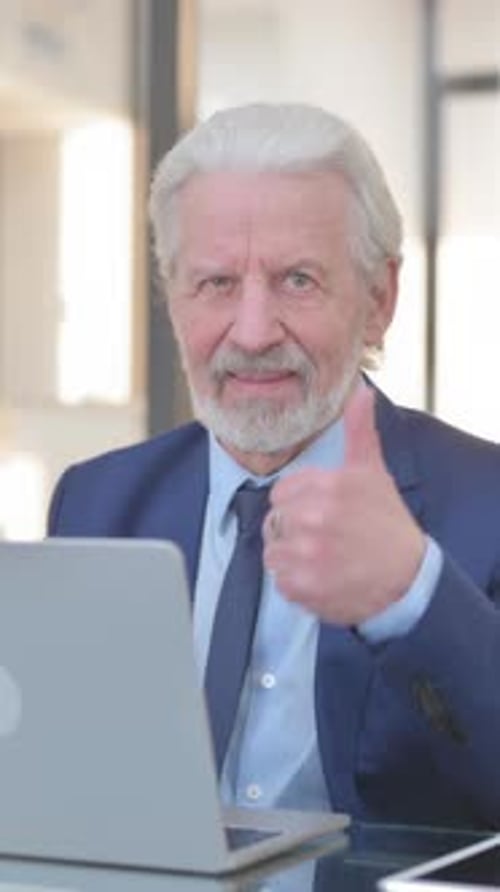 Old Businessman with Thumbs Up while Working in Office, vertical video