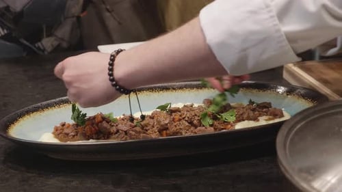 Chef Garnishing Braised Meat Dish
