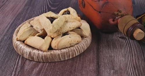 Hamantaschen Cookies, Grogger, and Mask on Table