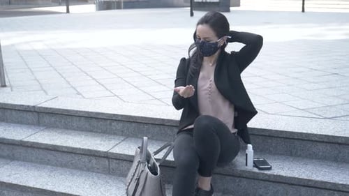 Businesswoman In Face Mask Apply Hand Sanitizer On Windy City Steps Slow Motion