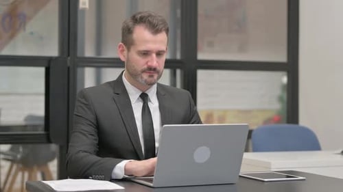 Professional Man Working on Laptop in Modern Office