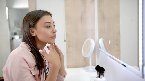Woman Examines Face in Vanity Mirror