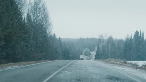 Winter Road FPV Camera Moves Along the Asphalt Road Covered with Snow During the Snow Blizzard