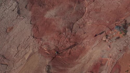 Top Down Aerial View of Couple of People Walking in Dry Desert Landscape on Hot Sunny Day, High Angl