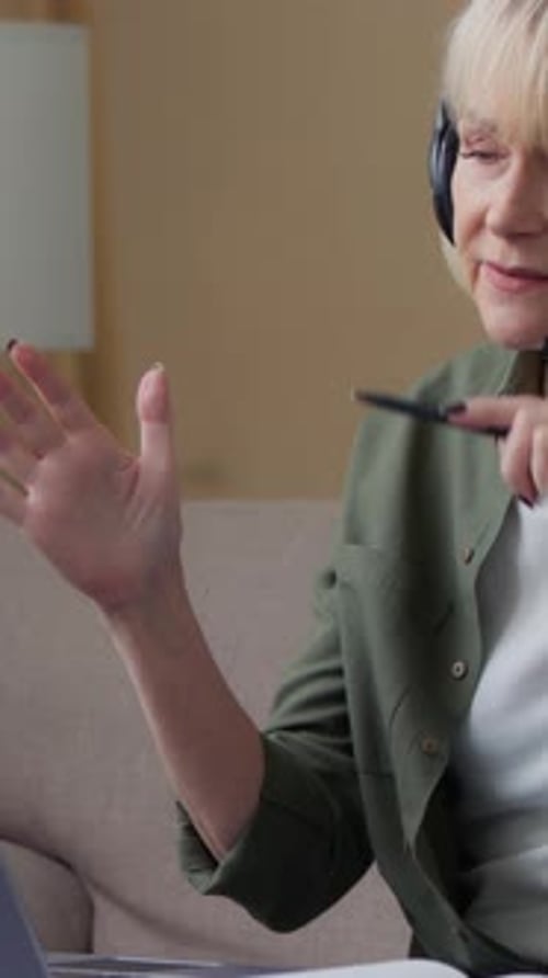 Woman with headset video conferencing from home