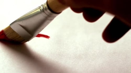 Malermalerei mit roter Farbe und Pinsel