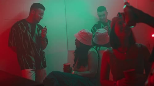 Diverse Millennial Couples Hanging out in Smoky All Gender Restroom in Club