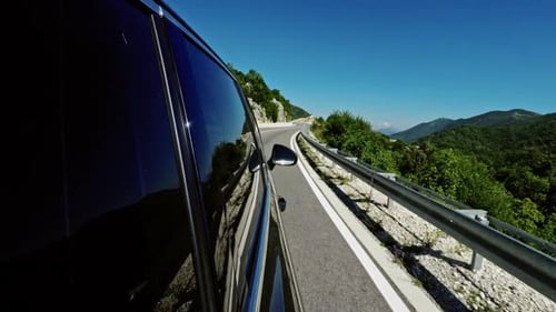 View Along the Side of a Car Driving on a Motorway in Mountainous Territory Passing Traffic Speed