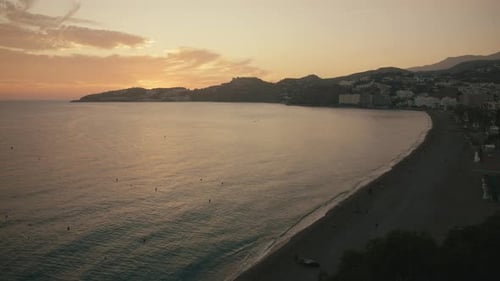 Almuñécar city beach and coastline at sunset with gentle waves