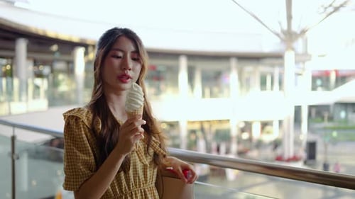 Young Woman Eating Ice Cream in an Urban Setting