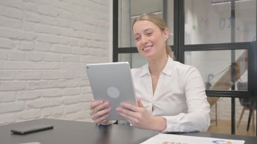 Mature Business Woman Doing Video Chat on Tablet in Office