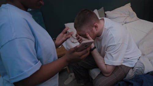 Woman Talking to Man Sitting on Bed