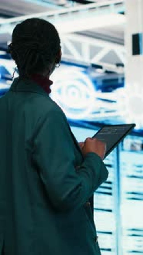 Vertical Video Female Programmer Walking in Data Center Using Tablet to Write Code