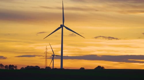 Wind Turbines Windmill Farm on Agricultural Fields at Incredible Multi Colored Cloudy Sunset in