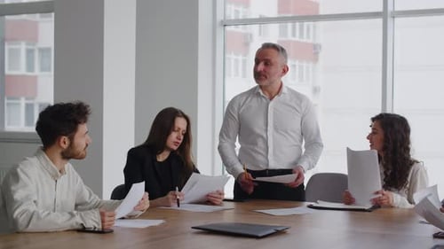 Team in Business Meeting Reviews Documents Together