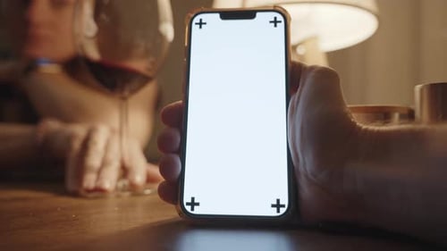 Smartphone with a Mockup of a White Screen and Tracking Markers. Date in a Restaurant.