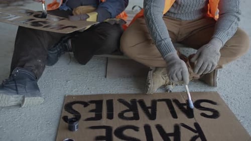 Construction Workers Painting Signs for Protest