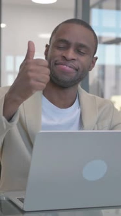 Man in Office Gives Thumbs Up at Laptop
