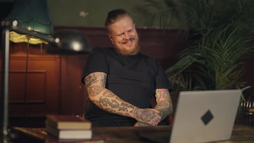 Joyful Bearded Man Watching Funny Videos By Laptop Sitting Alone in Apartment Middleaged Male Person