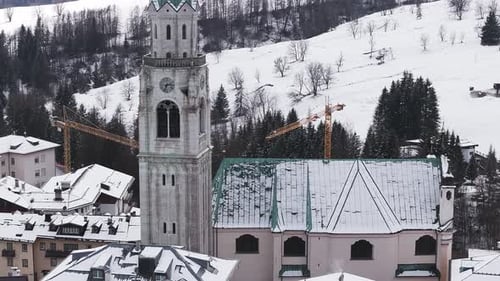 Aerial View of Cortina d'Ampezzo with Snowy Rooftops and Bell Tower