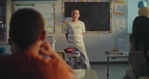 Elementary School Boy Presenting Homework on Ecology in Front of Classmates and Female Teacher