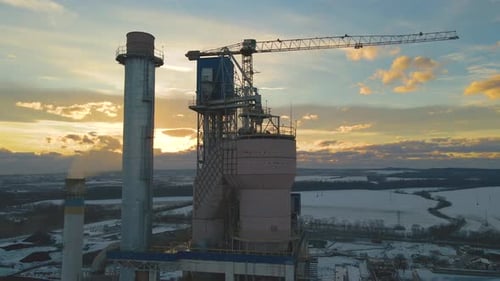 Aerial View of Cement Plant with High Factory Structure and Tower Crane at Industrial Production