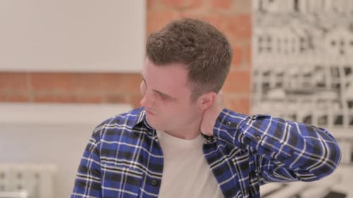 Young Adult Rubbing Neck in Discomfort