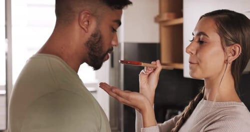 Woman Feeds Man Food in Modern Kitchen