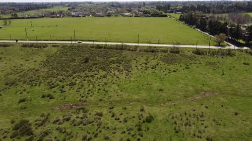 White small van driving by road in rural area of Buenos Aires, Argentina. Drone shot of a white van