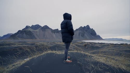 A Man Standing On The Black Sands Of Vestrahorn