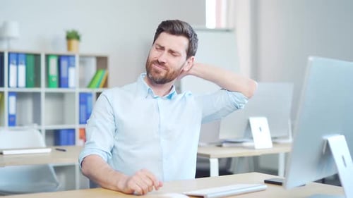 Man Rubbing Neck at Desk in Pain